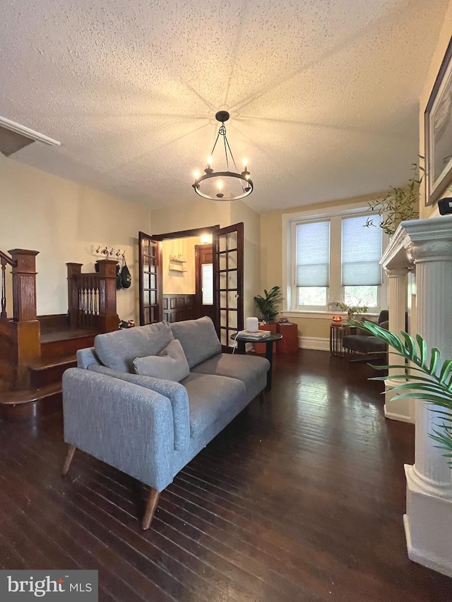 living room featuring a chandelier, a textured ceiling, and dark wood-type flooring