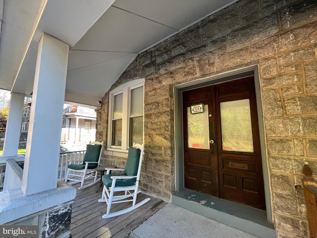 entrance to property featuring a porch and french doors