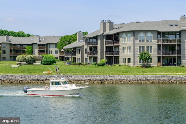 view of dock with a lawn and a water view