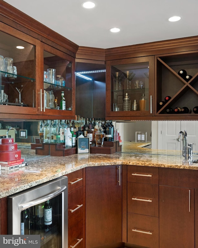 bar with light stone countertops and wine cooler