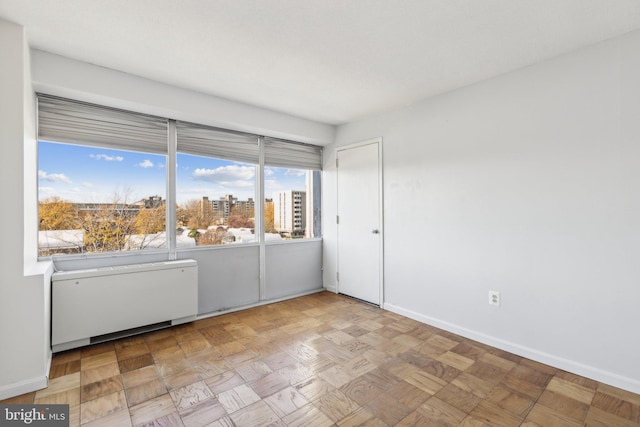 unfurnished room featuring radiator heating unit