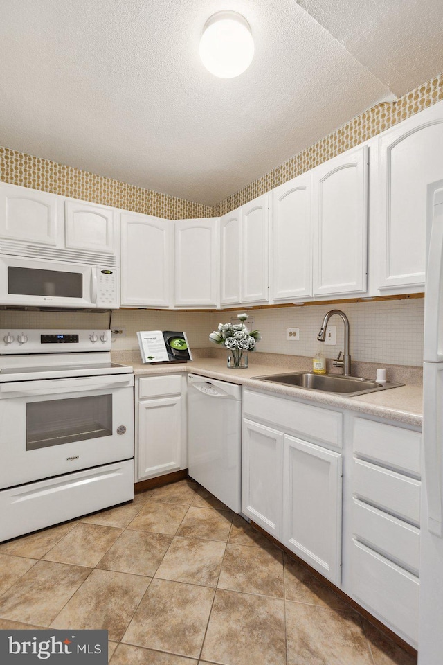 kitchen featuring white cabinets, white appliances, and sink