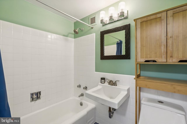 full bathroom featuring shower / bath combo, toilet, tile walls, and sink