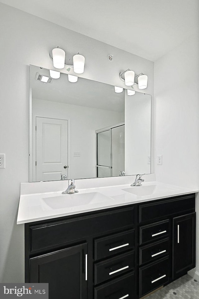 bathroom with a shower with door and vanity