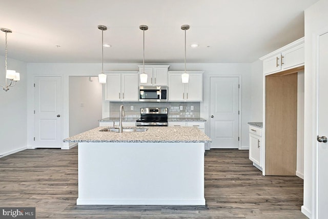 kitchen featuring appliances with stainless steel finishes, dark wood-type flooring, sink, a center island with sink, and white cabinets