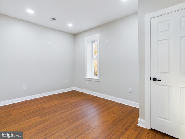 unfurnished room with dark hardwood / wood-style flooring