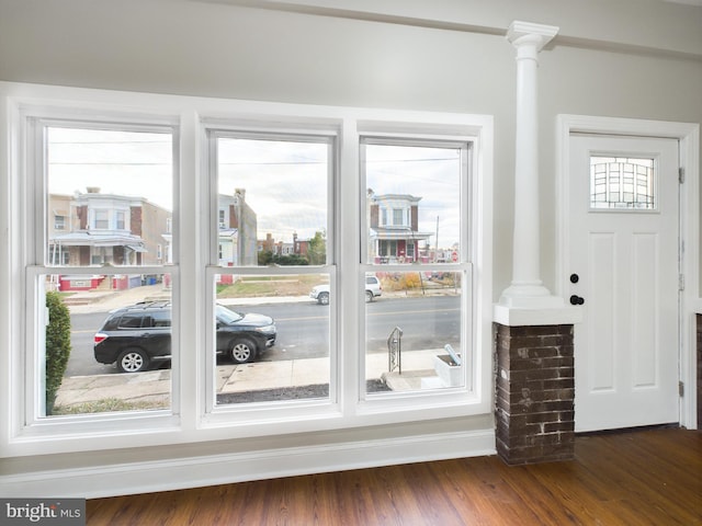 entryway featuring ornate columns and dark wood-type flooring