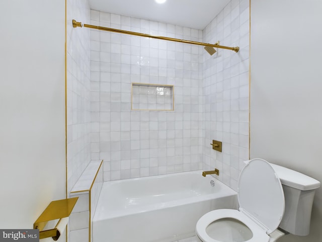 bathroom with tiled shower / bath combo and toilet