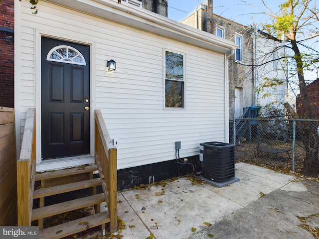 view of exterior entry featuring a patio area and central AC