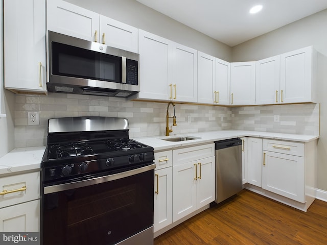 kitchen with white cabinetry, sink, stainless steel appliances, dark hardwood / wood-style floors, and decorative backsplash