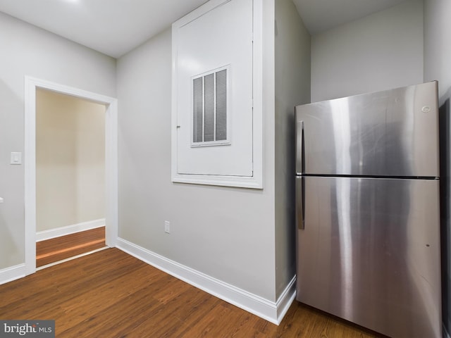 kitchen featuring dark hardwood / wood-style flooring, white cabinetry, and stainless steel refrigerator