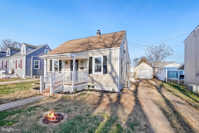 view of front of property featuring covered porch, a garage, and an outdoor structure