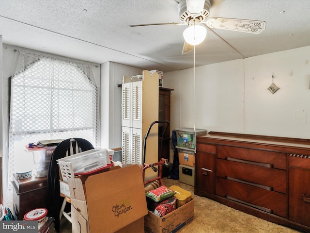 interior space with ceiling fan and a textured ceiling