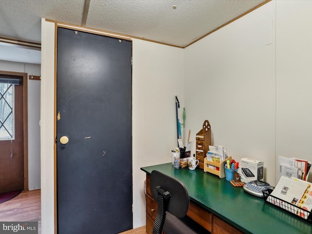 home office with a textured ceiling, hardwood / wood-style flooring, and ornamental molding