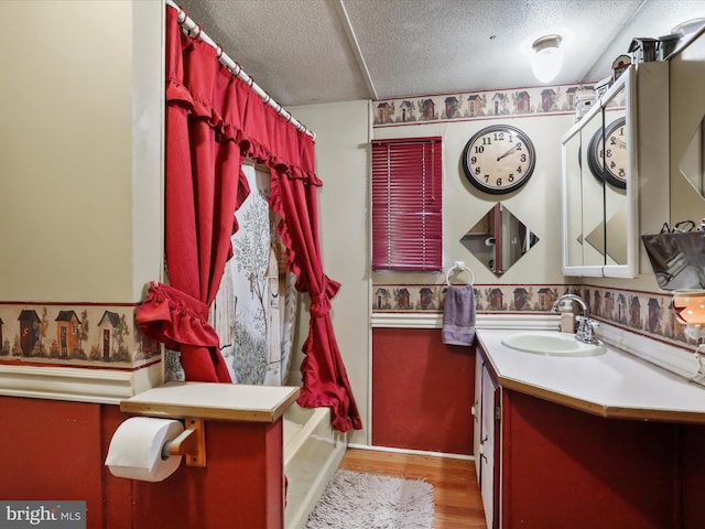 bathroom with shower / tub combo, hardwood / wood-style floors, vanity, and a textured ceiling