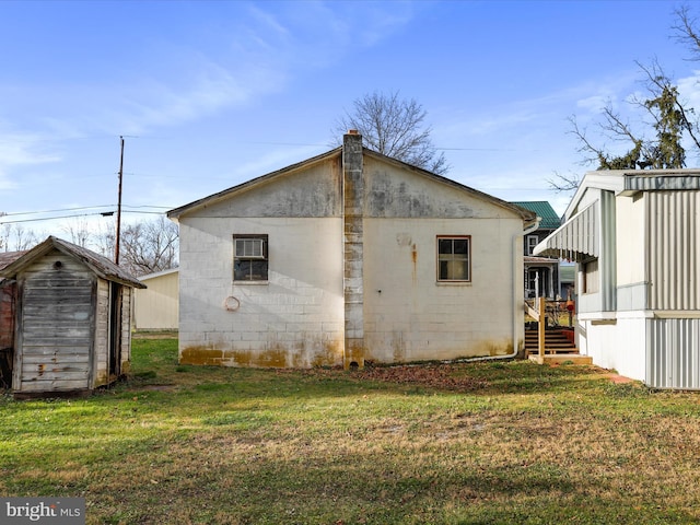 back of house with an AC wall unit, a storage unit, and a lawn