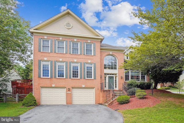 view of front of property with driveway, brick siding, an attached garage, and a front yard