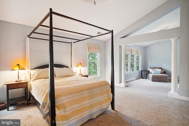 bedroom with ornate columns, carpet, and vaulted ceiling