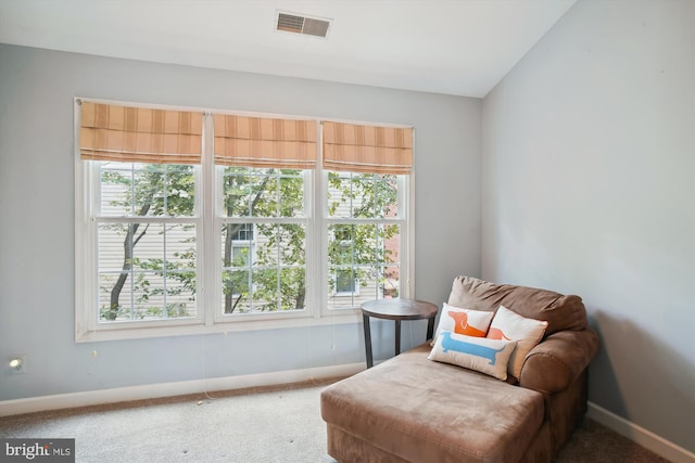 living area featuring carpet floors, a wealth of natural light, visible vents, and baseboards