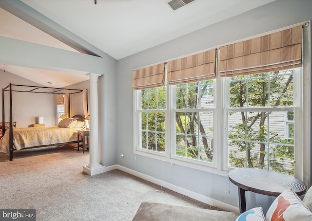 carpeted bedroom with lofted ceiling, baseboards, visible vents, and ornate columns