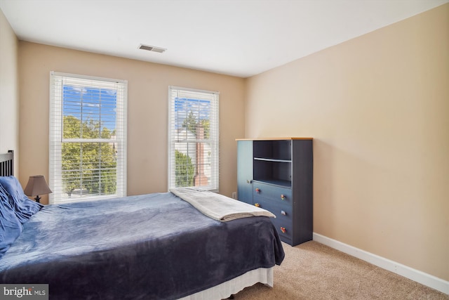 bedroom with carpet, visible vents, and baseboards