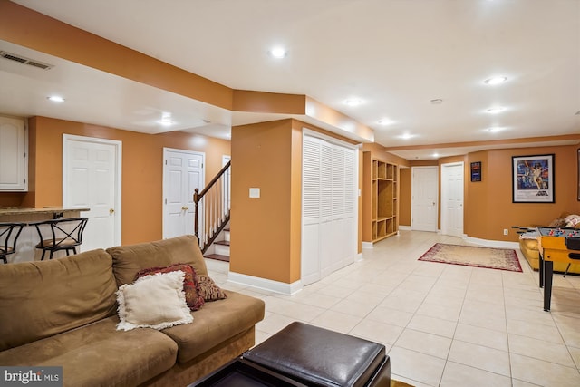 living area featuring light tile patterned floors, baseboards, stairs, and recessed lighting