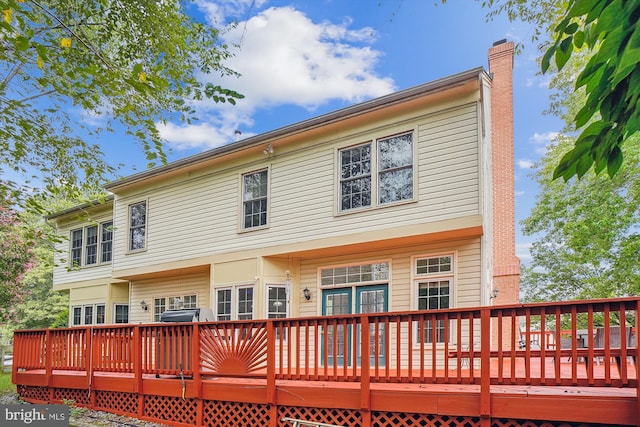 back of property with a deck and a chimney