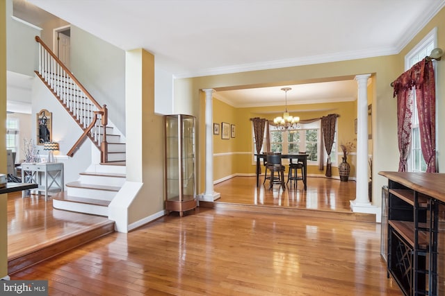 interior space with stairway, light wood-type flooring, decorative columns, and an inviting chandelier