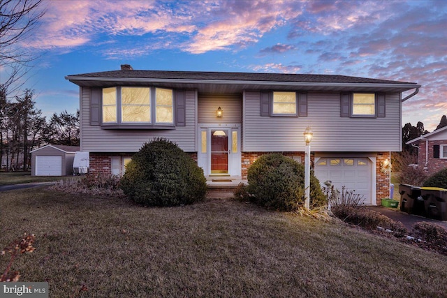 split foyer home featuring a lawn and a garage