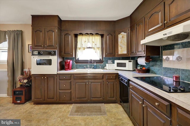 kitchen with backsplash, sink, black appliances, and dark brown cabinets