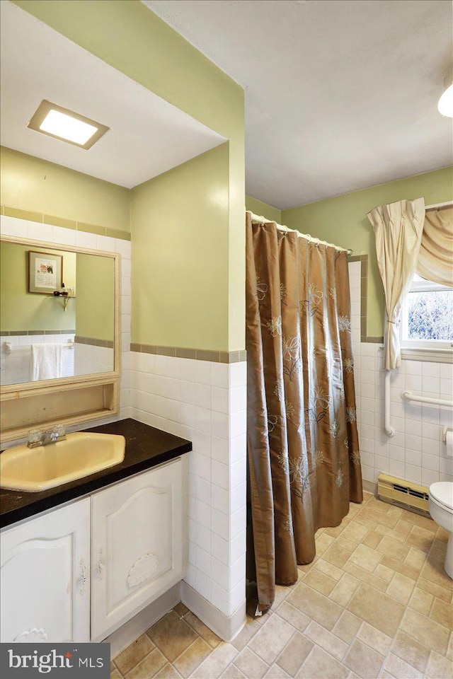 bathroom with vanity, a shower with curtain, toilet, tile walls, and a baseboard radiator