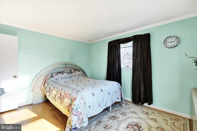 bedroom featuring light hardwood / wood-style floors and crown molding