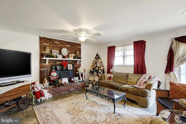 living room featuring a wood stove and ceiling fan