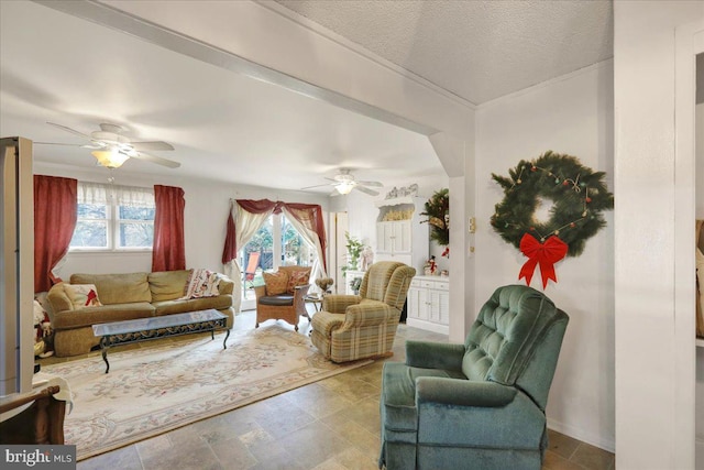 living room with ceiling fan and a textured ceiling