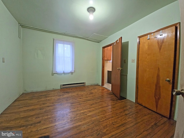 spare room featuring a baseboard radiator and dark hardwood / wood-style floors