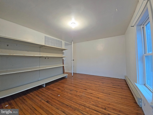 interior space with dark hardwood / wood-style flooring and baseboard heating