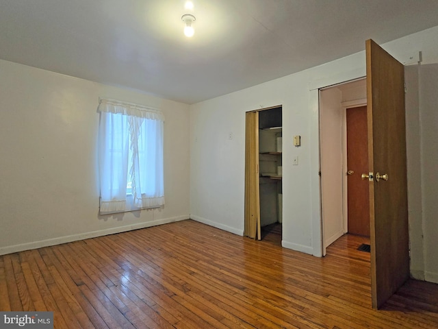 unfurnished bedroom featuring wood-type flooring and a closet