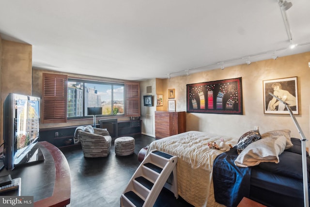 bedroom with rail lighting and dark wood-type flooring