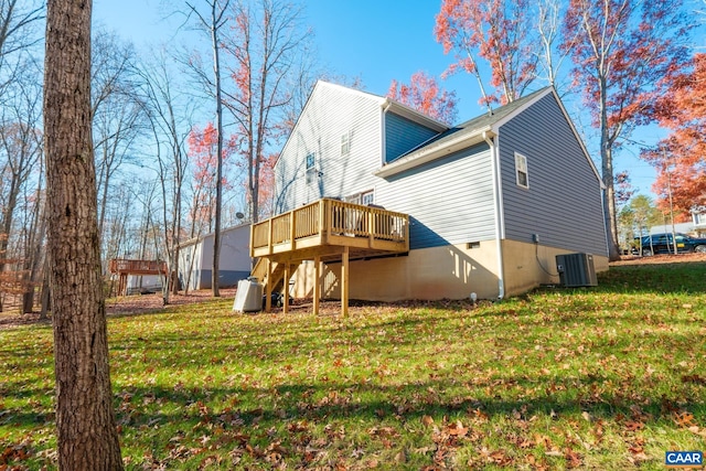 back of property with a wooden deck, a yard, and central AC