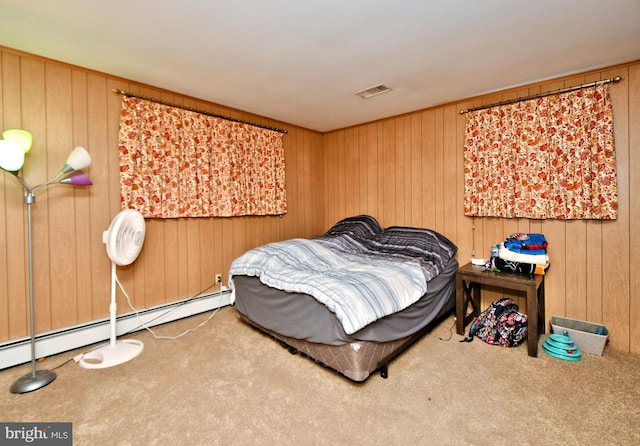 bedroom featuring carpet flooring, wood walls, and a baseboard heating unit