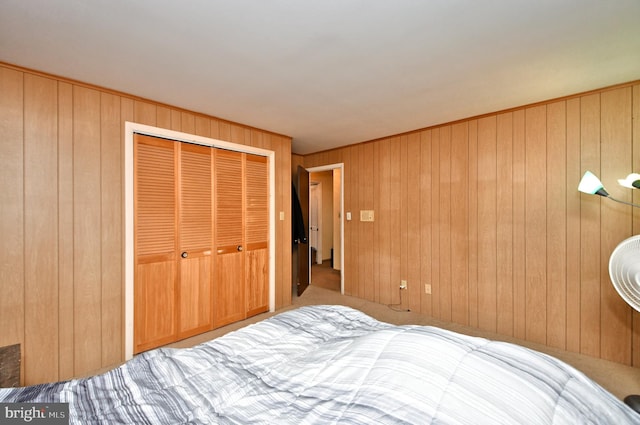 bedroom featuring carpet flooring, a closet, and wood walls