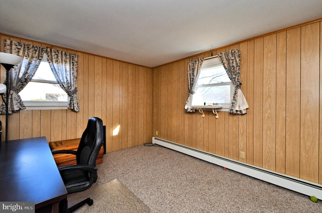 carpeted office space with a baseboard radiator and wood walls