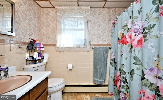 bathroom with a baseboard radiator, toilet, vanity, tile walls, and a shower with shower curtain