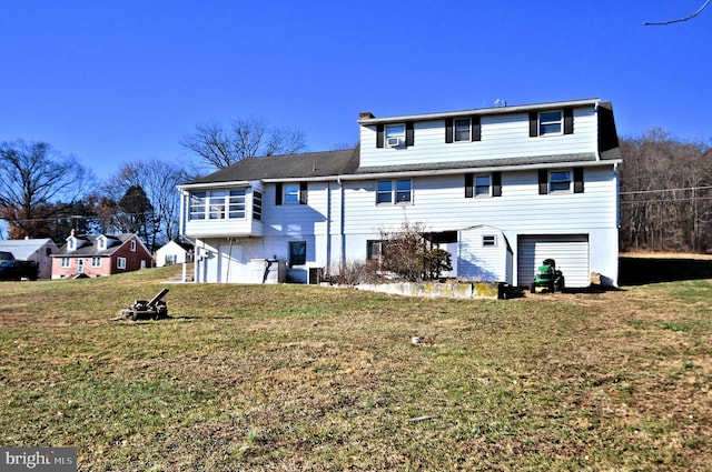 rear view of property featuring a garage and a lawn