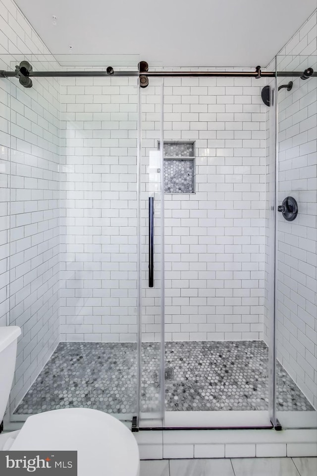 bathroom with toilet and an enclosed shower