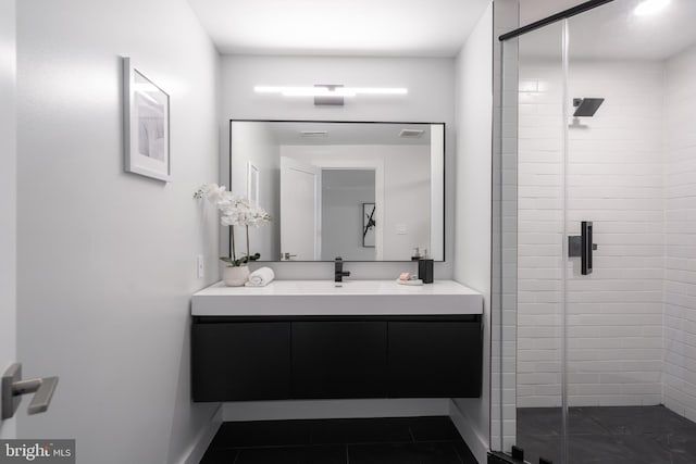 bathroom featuring a stall shower, tile patterned flooring, baseboards, and vanity