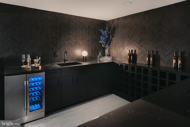 bar featuring decorative backsplash, wine cooler, wet bar, a sink, and light tile patterned flooring