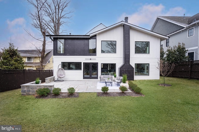 back of property with a fenced backyard, a lawn, and french doors