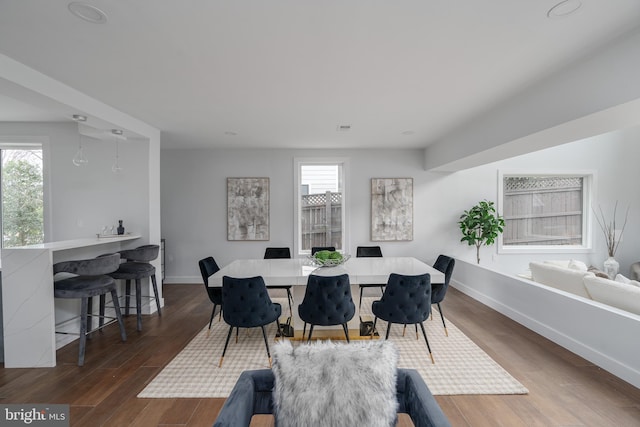 dining space with dark wood-style floors, visible vents, and baseboards