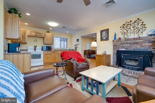 living room featuring ceiling fan, light wood-type flooring, and ornamental molding